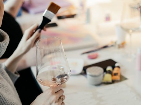 Zwei weiße Störche fliegen über einem bunten, abstrakten Hintergrund.