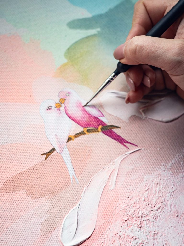 Eine Braut in einem eleganten Kleid, während sie an einem Kunstwerk malt.