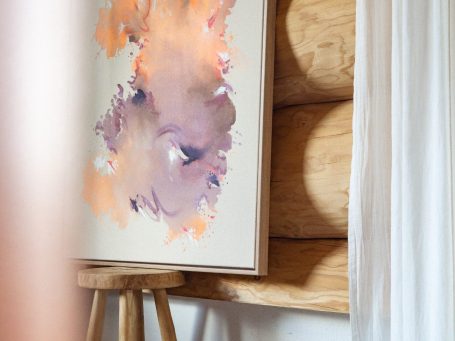 Abstrakte Malerei mit lila und orangefarbigen Farbtönen, in einem Holzhaus.