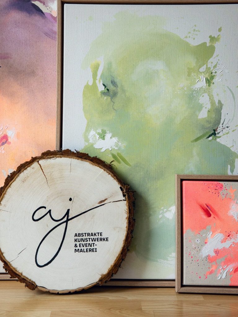 Zwei Bilder in sanften Farben und ein Holzschild mit Logo.