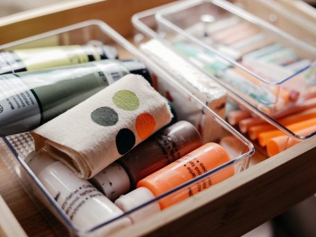 Bunte Heißluftballon fliegt über Wolken und Vögel im Himmel.