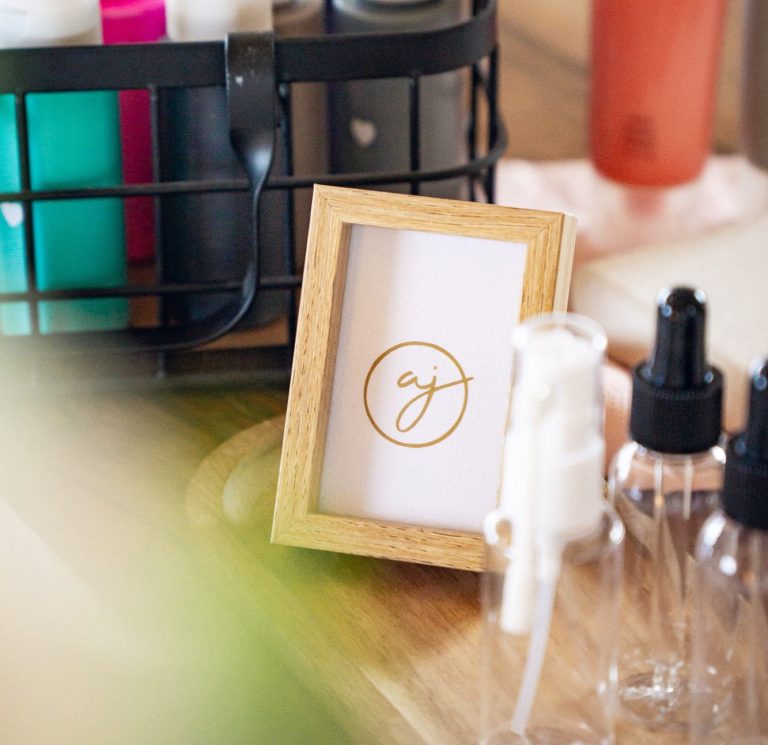 Ein Schild mit einem Logo steht neben mehreren Behältern und Flaschen auf einem Workshop-Tisch.