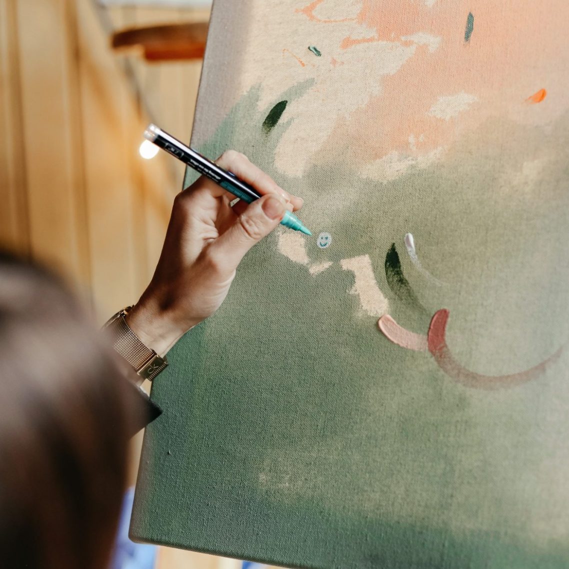 Eine Person malt auf einer Leinwand mit verschiedenen Farben und Pinselstrichen.