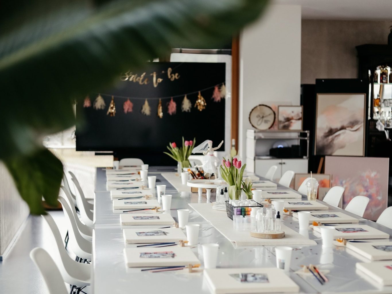 Bunt dekorierter Tisch mit Malutensilien und Getränken für einen kreativen Workshop.