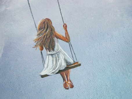 Hände halten einen Pinsel und malen auf einer Leinwand während einer Hochzeit.