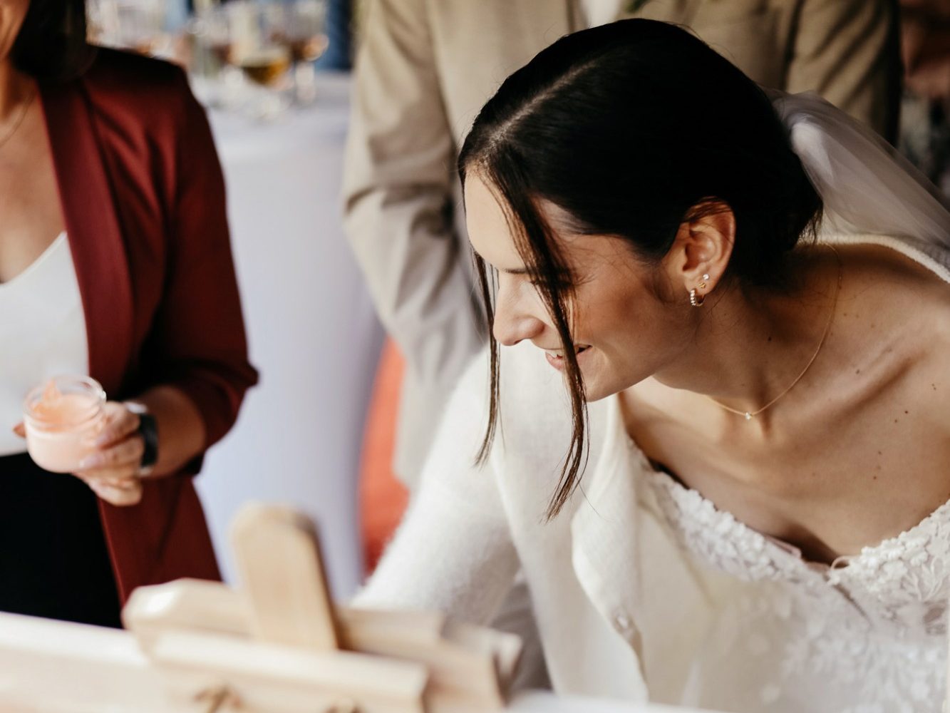 Braut in einem eleganten Kleid, die an einer Leinwand steht und malt.